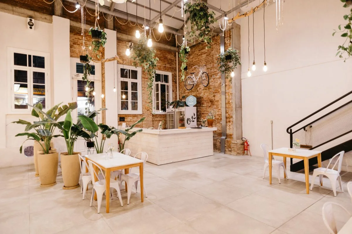 Bright restaurant interior with white chairs and indoor plants